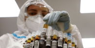 Медик размещает пробирки с пробами на коронавирус на центрифуге в лаборатории больницы с коронавирусом 