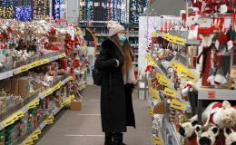 Девушка выбирает елочные игрушки в магазине, архивное фото Девушка выбирает елочные игрушки в магазине, архивное фото