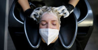Женщина в маске у парикмахера в салоне