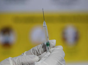 Медик держит в руках шприц с вакциной от коронавируса 