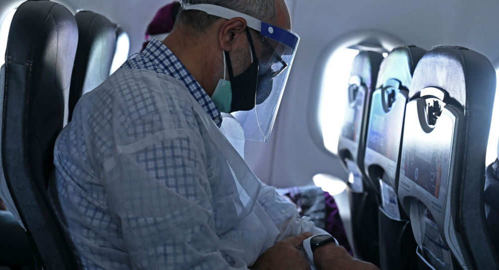 Мужчина в защитной маске в салоне самолета 