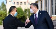 Глава МИД Казахстана Мухтар Тлеуберди здоровается локтями со своим китайским коллегой Ван И
