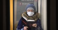 Женщина в защитной маске в вагоне поезда, архивное фото