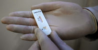 Медик держит в руках экспресс-тест на коронавирус