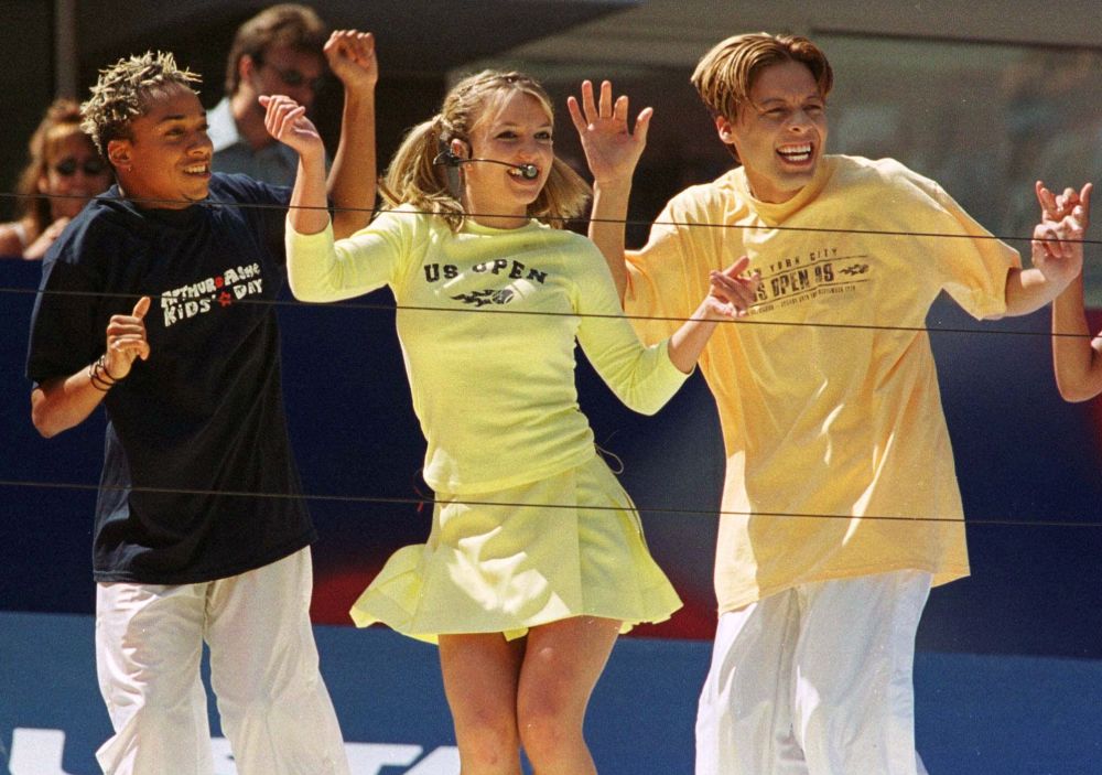 Бритни Спирс (в центре) выступает с танцорами во время Дня детей Артура Эша в Национальном теннисном центре USTA в субботу, 28 августа 1999 года, Нью-Йорк