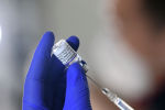 Медик набирает вакцину от коронавируса в шприц