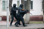 Вооруженные сотрудники ОМОНа готовятся открыть огонь, контролируя улицу после столкновений в Алматы
