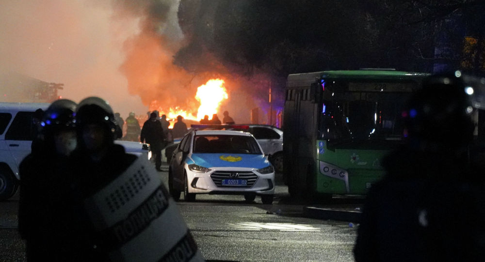 Полицейские в огне во время столкновений с протестующими в центре Алматы, Казахстан, среда, 5 января 2022 г. 