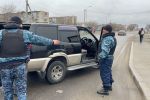 Сотрудники блокпоста осматривают автомобиль в Талдыкоргане 