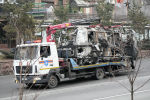 Эвакуатор экстренной службы вывозит сожженный автомобиль с улицы Алматы