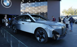 Люди смотрят на прототип BMW iX Flow на стенде BMW во время технической выставки CES в среду, 5 января 2022 года, в Лас-Вегасе. iX Flow — это система, которая заменяет обычную автомобильную краску на технологию электронных чернил, которая позволяет автомобилю менять цвет и дизайн