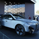 Люди смотрят на прототип BMW iX Flow на стенде BMW во время технической выставки CES в среду, 5 января 2022 года, в Лас-Вегасе. iX Flow — это система, которая заменяет обычную автомобильную краску на технологию электронных чернил, которая позволяет автомобилю менять цвет и дизайн