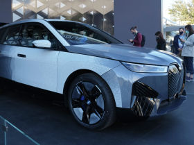 Люди смотрят на прототип BMW iX Flow на стенде BMW во время технической выставки CES в среду, 5 января 2022 года, в Лас-Вегасе. iX Flow — это система, которая заменяет обычную автомобильную краску на технологию электронных чернил, которая позволяет автомобилю менять цвет и дизайн