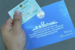 Избиратель держит в руках приглашение на выборы президента Казахстана-2019