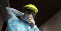 Медик поправляет защитную маску в больнице с коронавирусом 