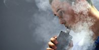 Мужчина курит вейпер, архивное фото