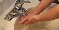 Человек моет руки под струей воды из-под крана, иллюстративное фото