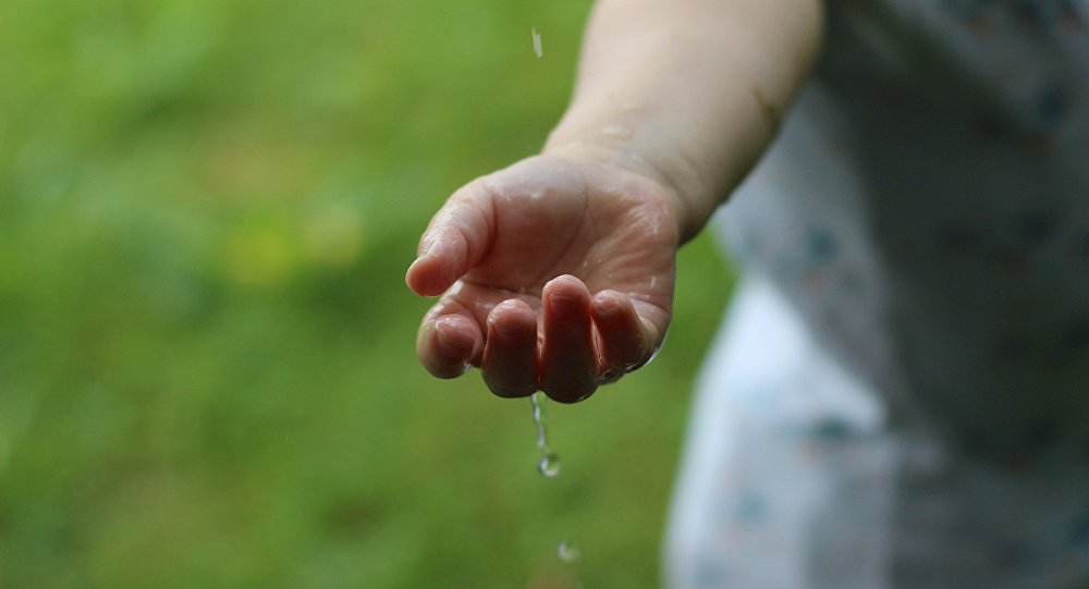 Ребенок играет с водой, архивное фото