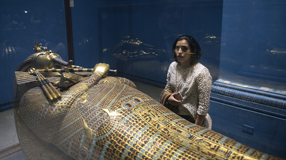 Женщина рассматривает золотой саркофаг фараона Тутанхамона, выставленный в Египетском музее в столице Каире