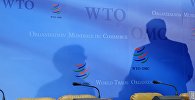 Архивное фото логотипов Всемирной торговой организации (ВТО), на фоне которых просматриваются тени делегатов министерского саммита в штаб-квартире в Женеве