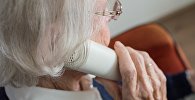 Пожилая женщина говорит по телефону, иллюстративное фото