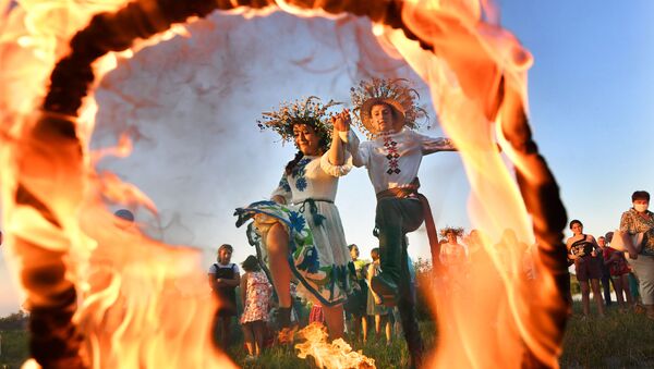Девушка и юноша прыгают через огонь на празднике Ивана Купалы на берегу залива Припяти в древнем белорусском Турове - Sputnik Казахстан