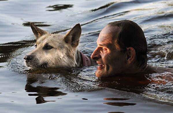 Мужчина с собакой на празднике Ивана Купалы на берегу залива Припяти в древнем белорусском Турове - Sputnik Казахстан