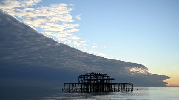 Облака, напоминающие огромную волну, над пляжем в Брайтоне на юге Англии - Sputnik Казахстан