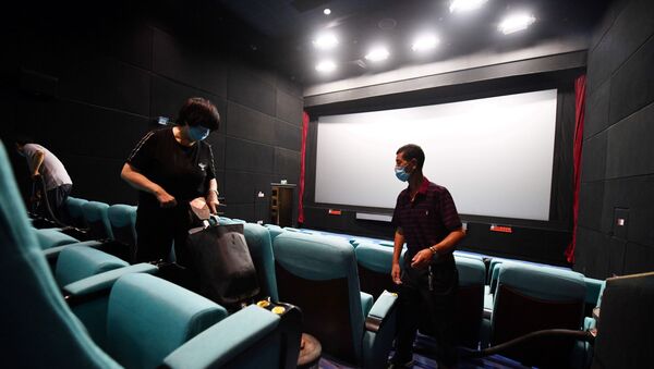 Работники кинотеатра в масках делают уборку в зрительном зале - Sputnik Қазақстан