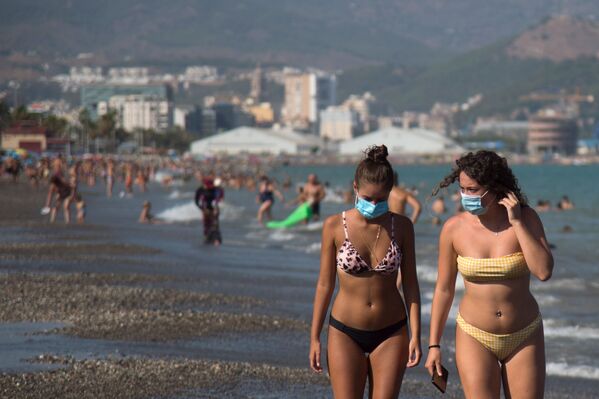 Девушки в защитных масках на пляже Мизерикордия в Малаге, Испания  - Sputnik Казахстан