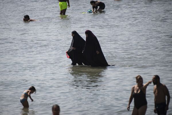 Мусульманки в чадре купаются в море на пляже в Марселе, Франция  - Sputnik Казахстан