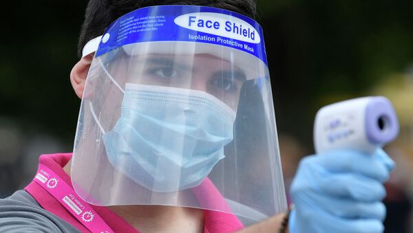 Сотрудник торгового центра в защитной маске измеряет температуру посетителям - Sputnik Қазақстан