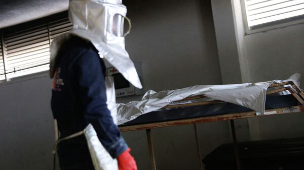 Сотрудник морга рядом с телом погибшего от коронавируса  - Sputnik Казахстан