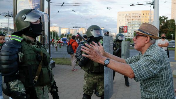 Пожилой человек обращается к бойцам полицейского спецназа во время протестов в Минске  - Sputnik Қазақстан