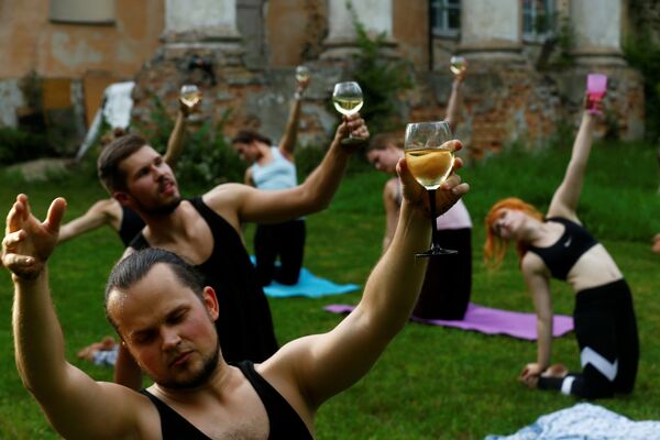 Люди с бокалами вина во время йоги в Латвии  - Sputnik Казахстан