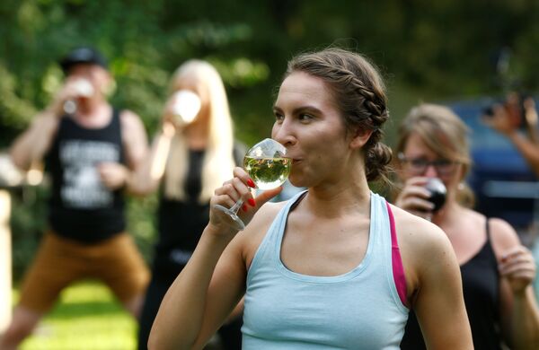Девушка пьет вино во время йоги в Латвии  - Sputnik Казахстан