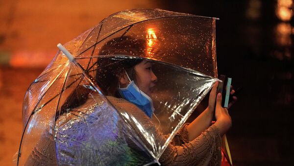 Девушка под зонтом беседует в видеочате - Sputnik Казахстан