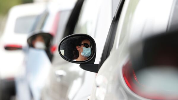 Отражение в зеркале заднего вида женщины в маске, которая стоит в автомобильной пробке - Sputnik Казахстан