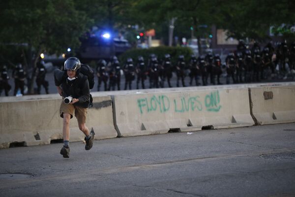Фотограф убегает от полицейских во время протестов в Миннеаполисе, США - Sputnik Казахстан