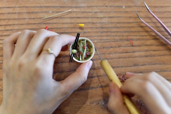 Вьетнамская художница Nguyen Thi Ha An с миниатюрной тарелкой с едой в своей студии в Ханое  - Sputnik Казахстан