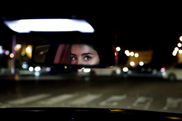 Глаза девушки в зеркале заднего вида машины в Саудовской Аравии  - Sputnik Казахстан