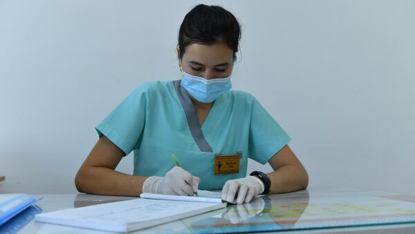 Медсестра в поликлинике вносит данные пациентов во время приема - Sputnik Қазақстан