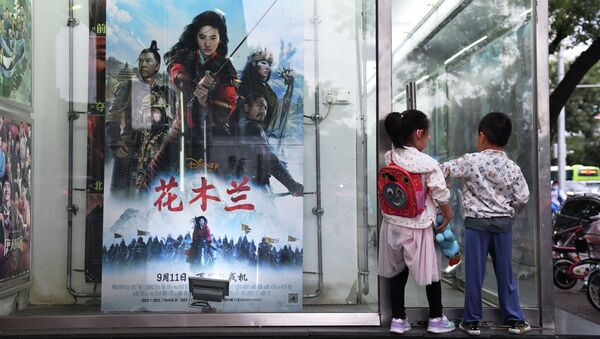  Дети возле плаката к фильму Диснея Мулан на автобусной остановке в день открытия фильма в Пекине 11 сентября 2020 год - Sputnik Казахстан