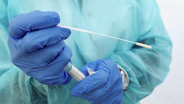 Медик держит в руках пробирку для ПЦР-анализа на коронавирус - Sputnik Қазақстан