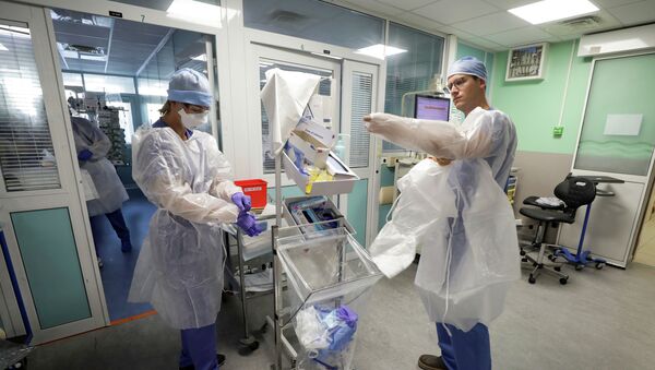 Медики надевают защитные костюмы перед началом смены в больнице с коронавирусом  - Sputnik Казахстан