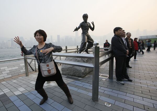 Туристы позируют у бронзовой статуи Брюса Ли в Гонконге  - Sputnik Казахстан