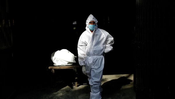 Работник морга рядом с телом погибшего от коронавируса  - Sputnik Казахстан
