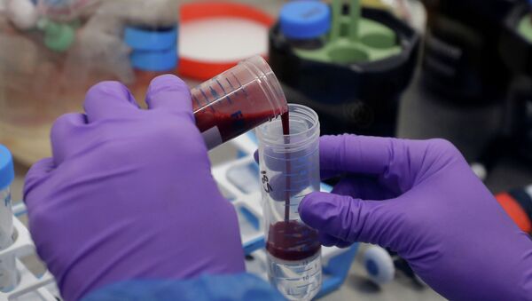 Сотрудник лаборатории переливает пробу крови из пробирки для анализа на коронавирус - Sputnik Казахстан