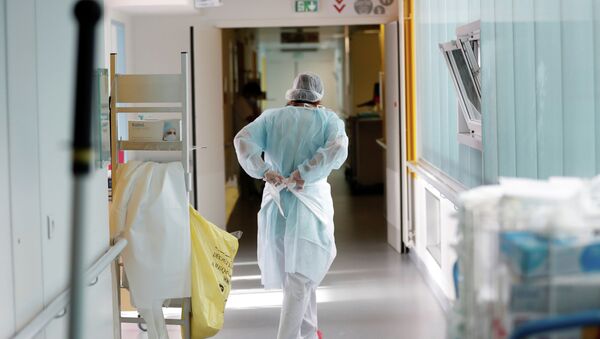 Врач надевает защитный костюм в коридоре больницы с коронавирусом  - Sputnik Қазақстан