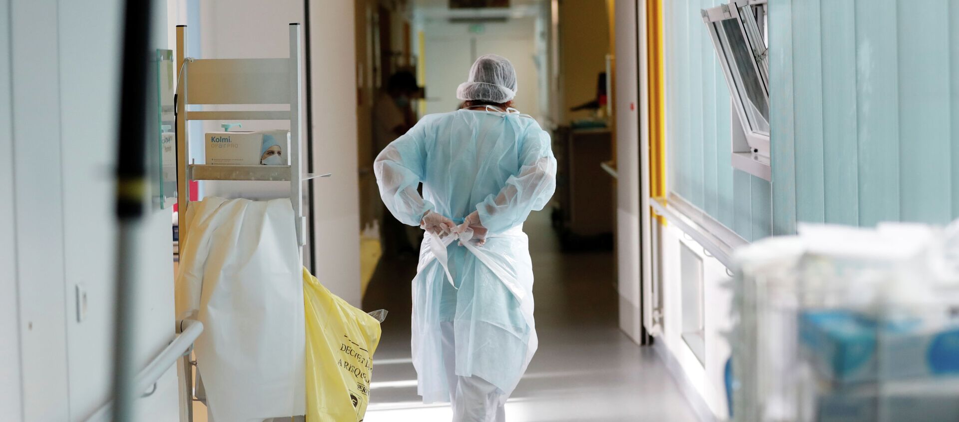 Врач надевает защитный костюм в коридоре больницы с коронавирусом  - Sputnik Қазақстан, 1920, 04.02.2021